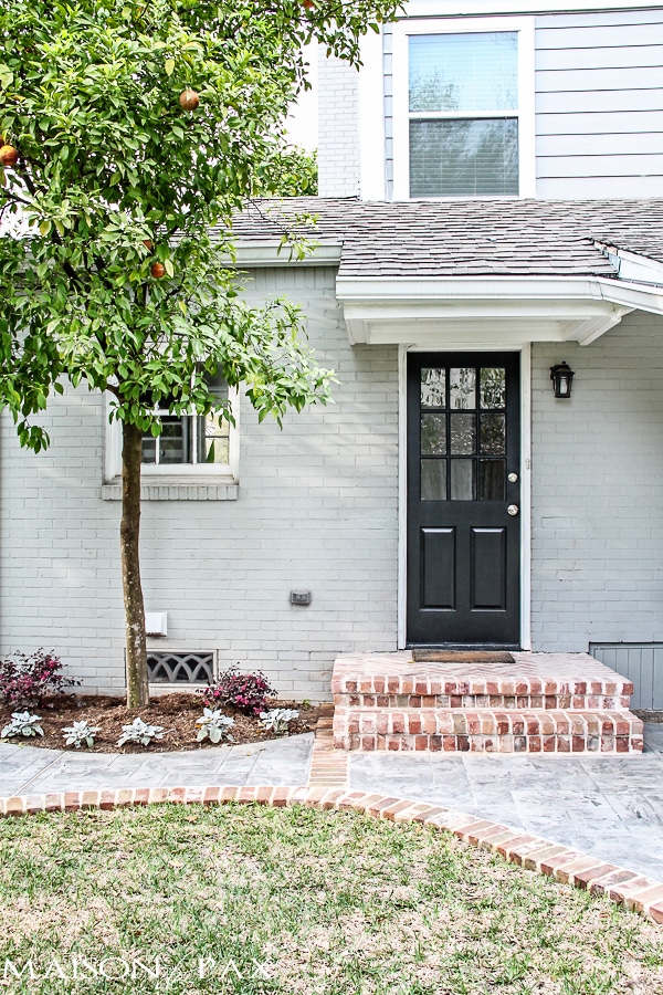 gray house with brick steps and black door | maisondepax.com