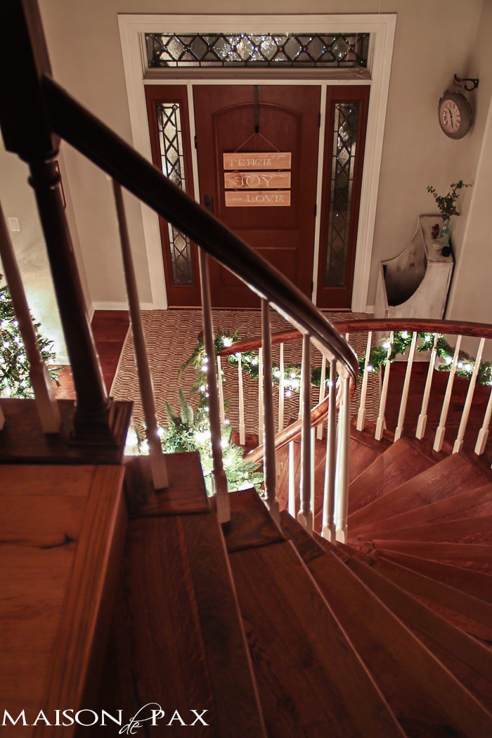 stairs lit with lighted garland for Christmas - gorgeous entry