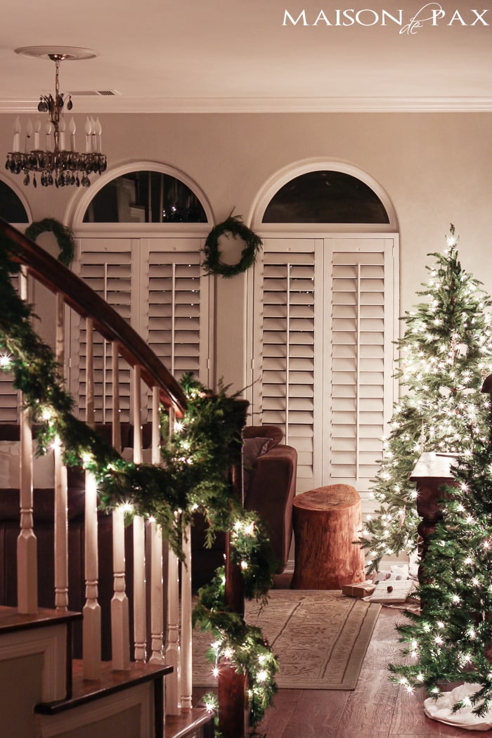 holiday decorating: christmas tree with white lights, mini tree, wreaths, lighted garland on stairs