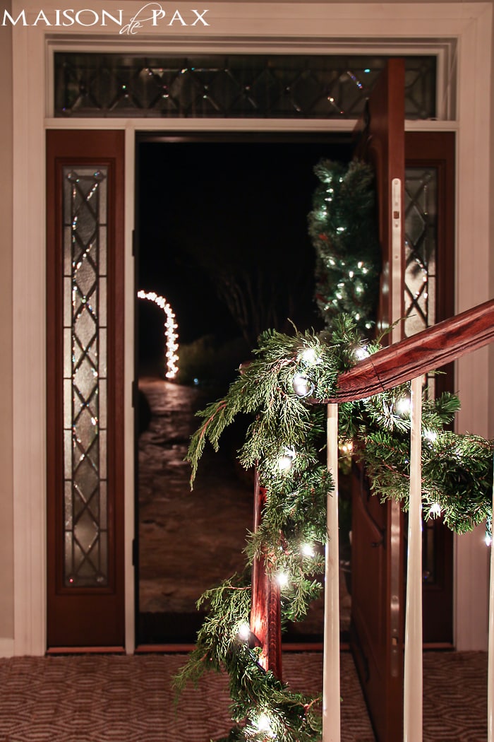 lighted garland and a lighted archway make this holiday entryway simply beautiful