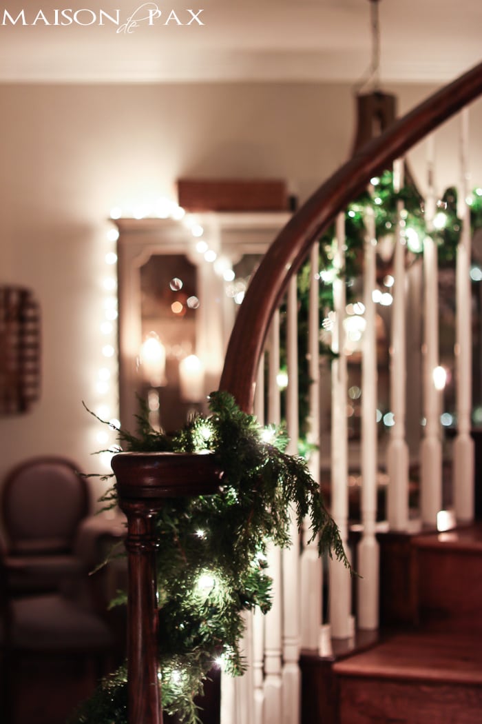 lighted garland on stairs, string lights on china cabinet