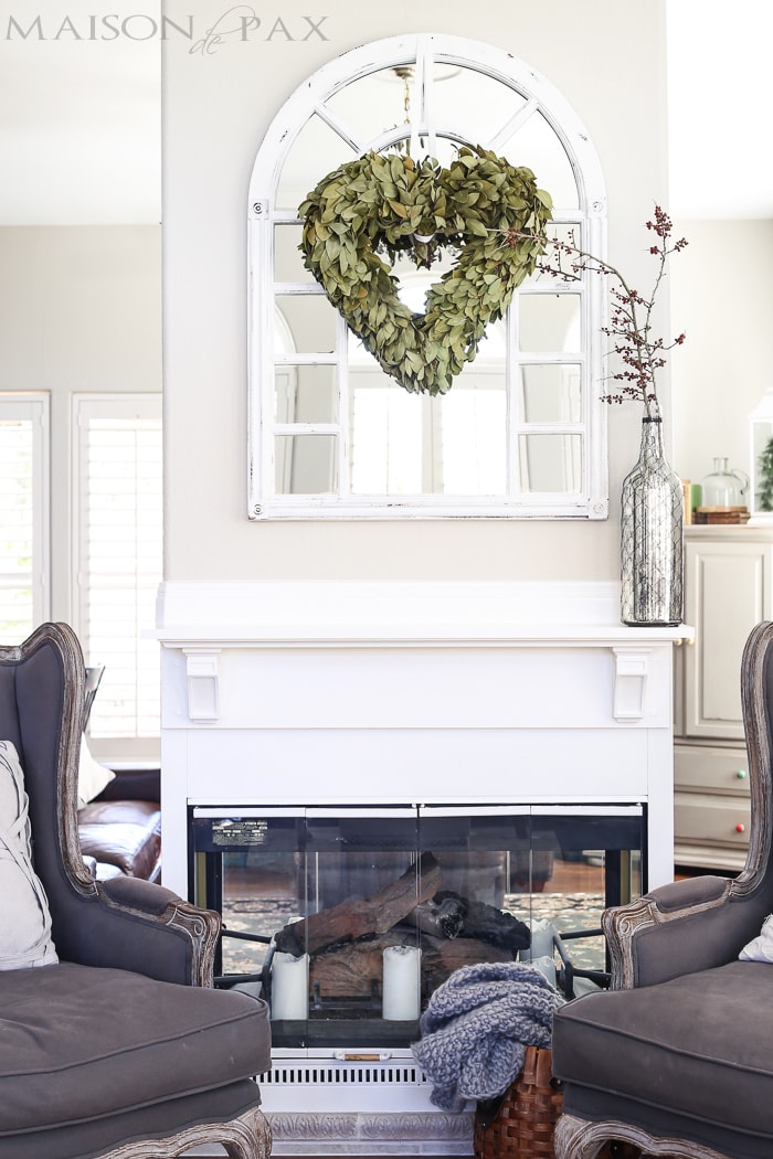 heart shaped bay leaf wreath over window style mirror above mantel - love all the white
