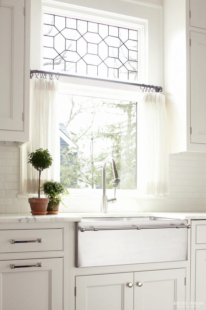 farmhouse sink, marble counters, and decorative window