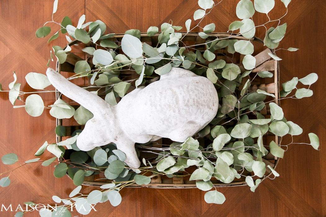 What a cute, simple idea for Easter decor! Use a garden statue bunny in a basket with dried greens as a centerpiece for your table | maisondepax.com