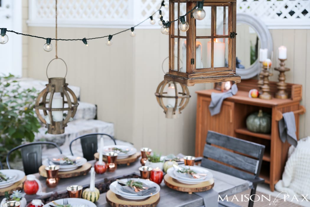 outdoor fall tablescape: lanterns, string lights, apple candles, and other cozy outdoor fall decorating ideas!