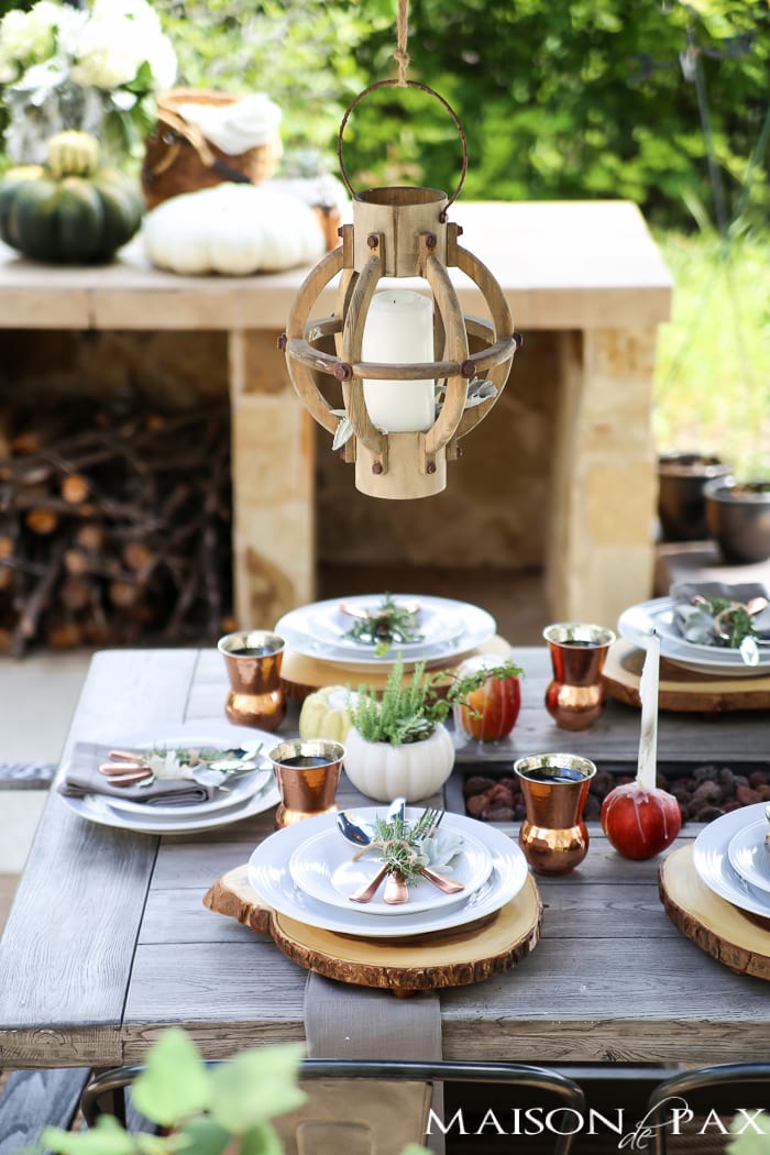 outdoor fall tablescape: lanterns, string lights, apple candles, and other cozy outdoor fall decorating ideas!