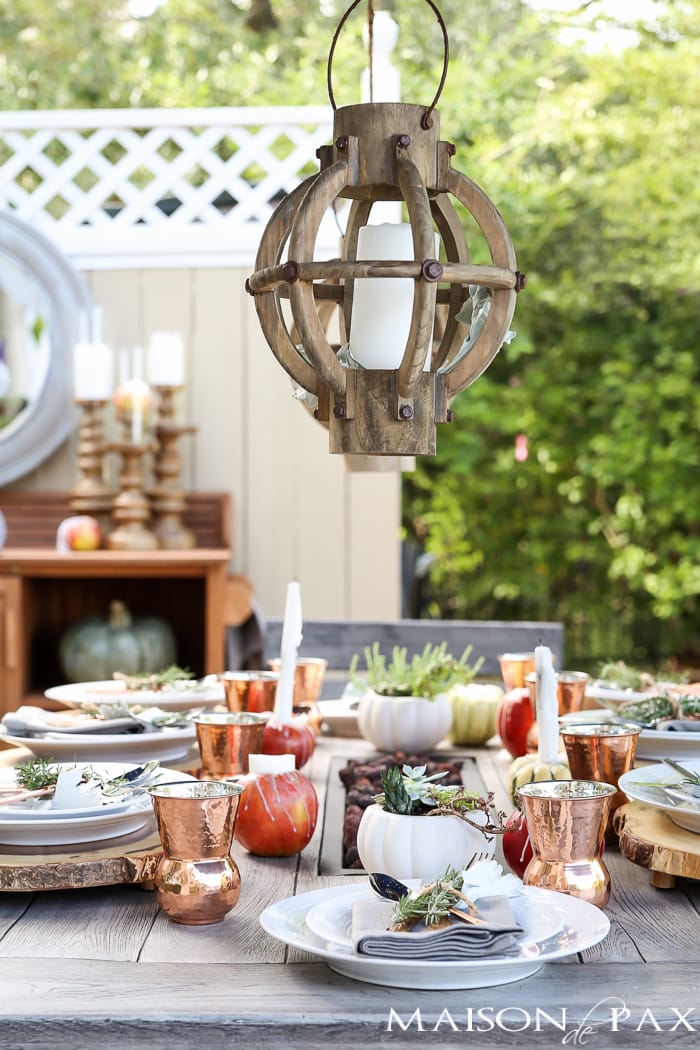 10 tips for a magical outdoor dining table: lanterns, string lights, apple candles, and other cozy outdoor fall decorating ideas!