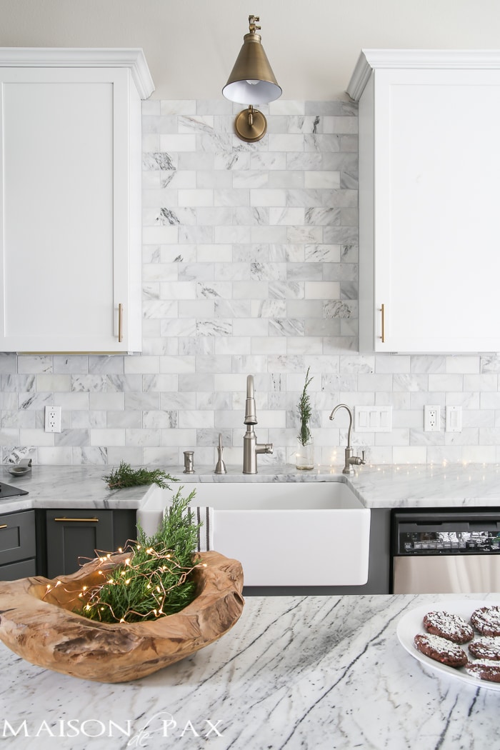 Gorgeous two-tone kitchen design with white upper cabinets, gray lower cabinets, carrara marble counters and marble subway tile backsplash- Maison de Pax