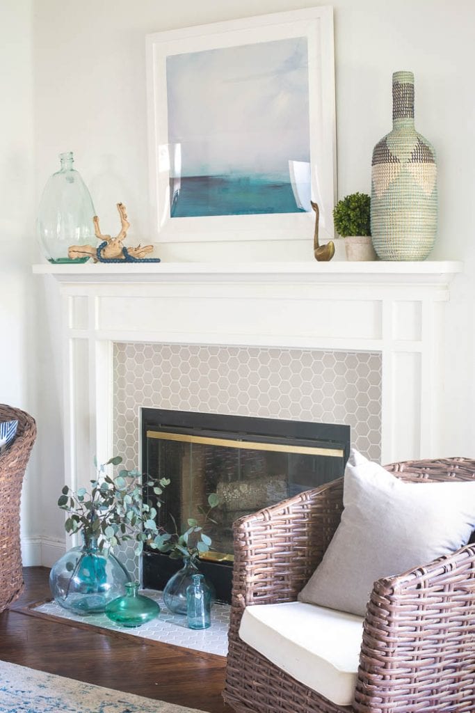 What a fun beachy vibe in this coastal living room! Blues, greens, weathered wood, and DIY wall art make it a beautiful, comfortable space.