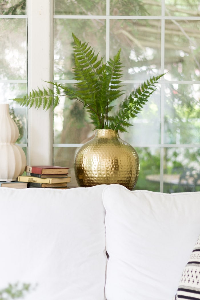 White couch and green fern in gold vase- Maison de Pax