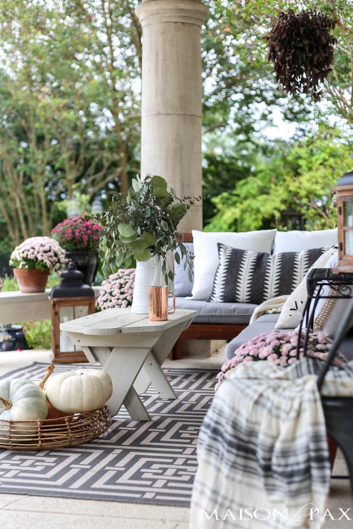 gorgeous fall porch with neutral pillows and blankets and pastel mums and pumpkins- Maison de Pax