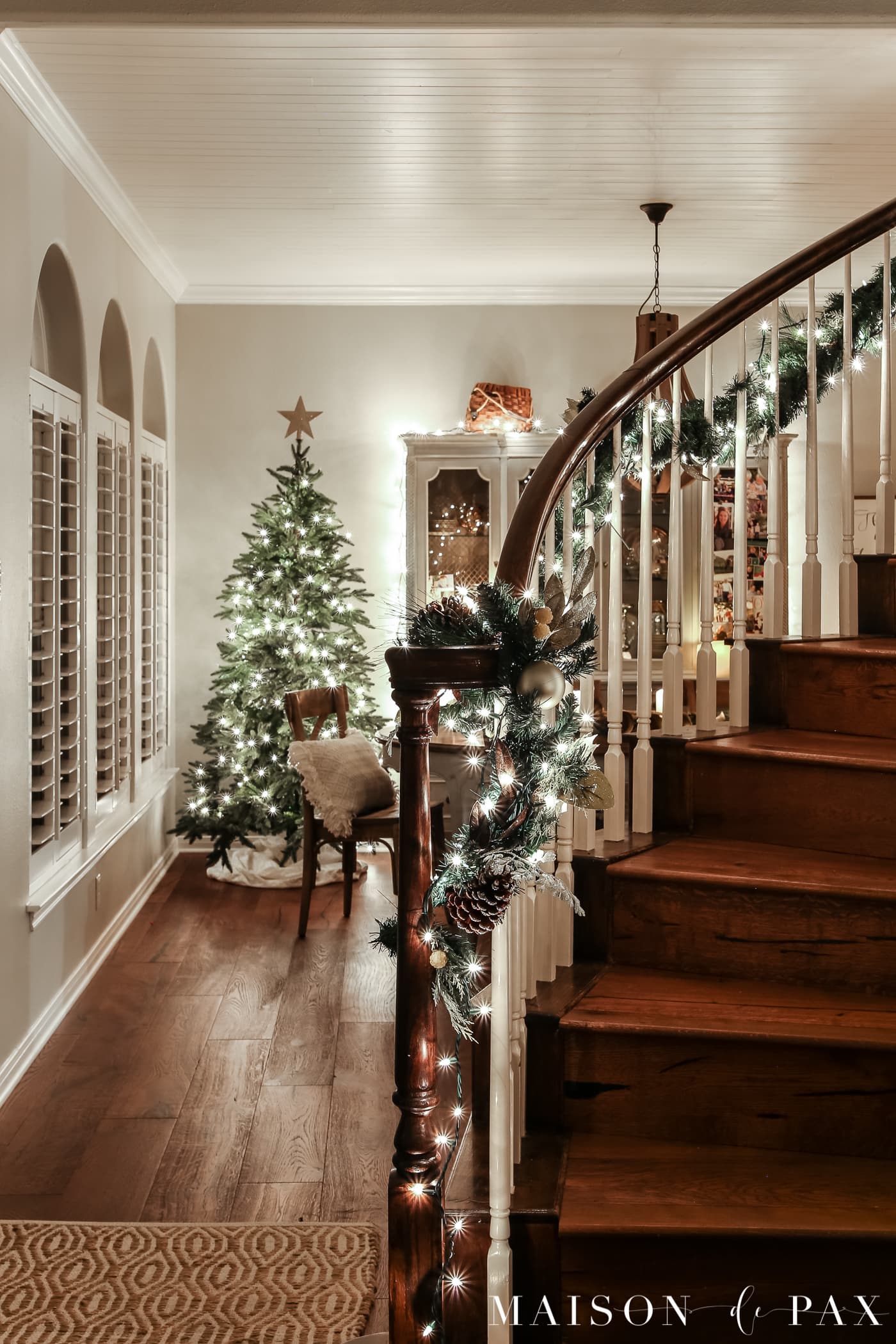 stair garland with lights: gorgeous Christmas lights at night in these 25+ home tours #christmasnightstour #holidayhometour #christmaslights