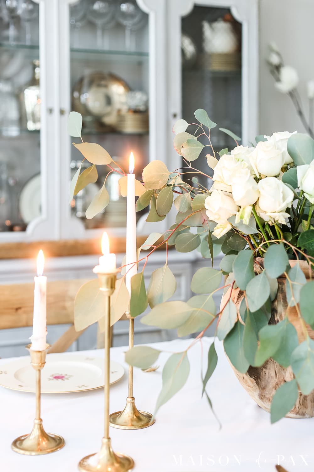 lovely brass candlesticks with white roses and eucalyptus centerpiece- Maison de Pax