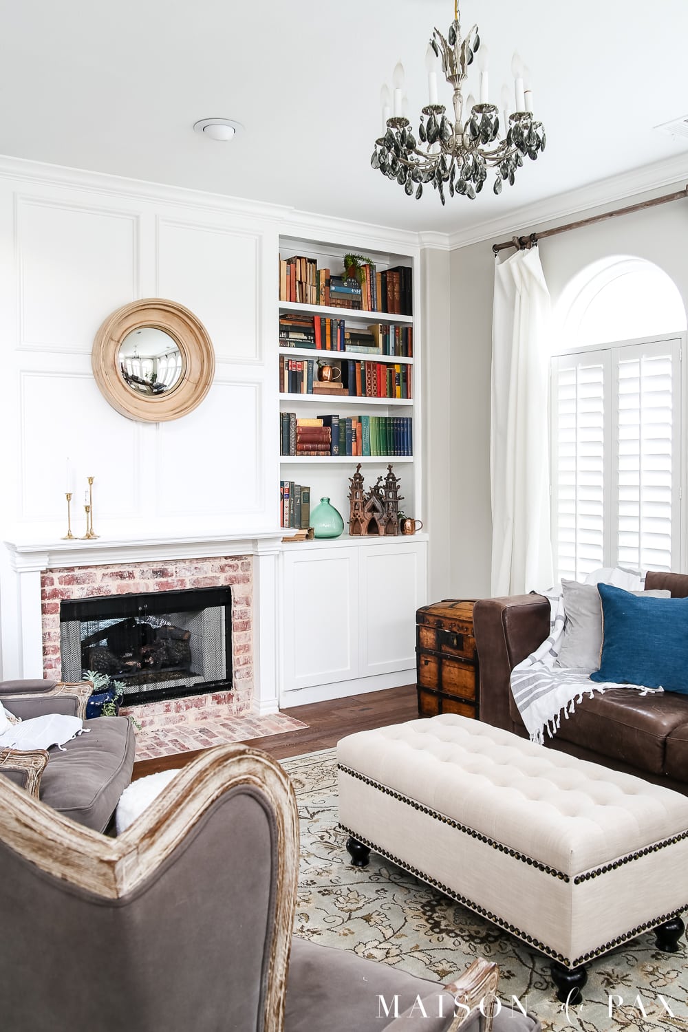 Neutral living room with colorful antique books: Wondering how to seasonally decorate your living spaces without going to too much trouble?  Get my best tips for transitioning from winter whites to neutrals, blues, and greens for a spring living room. #springdecor #springdecorating #springlivingroom #antiquebooks #howtodecorate #seasonaldecor #seasonaldecorating