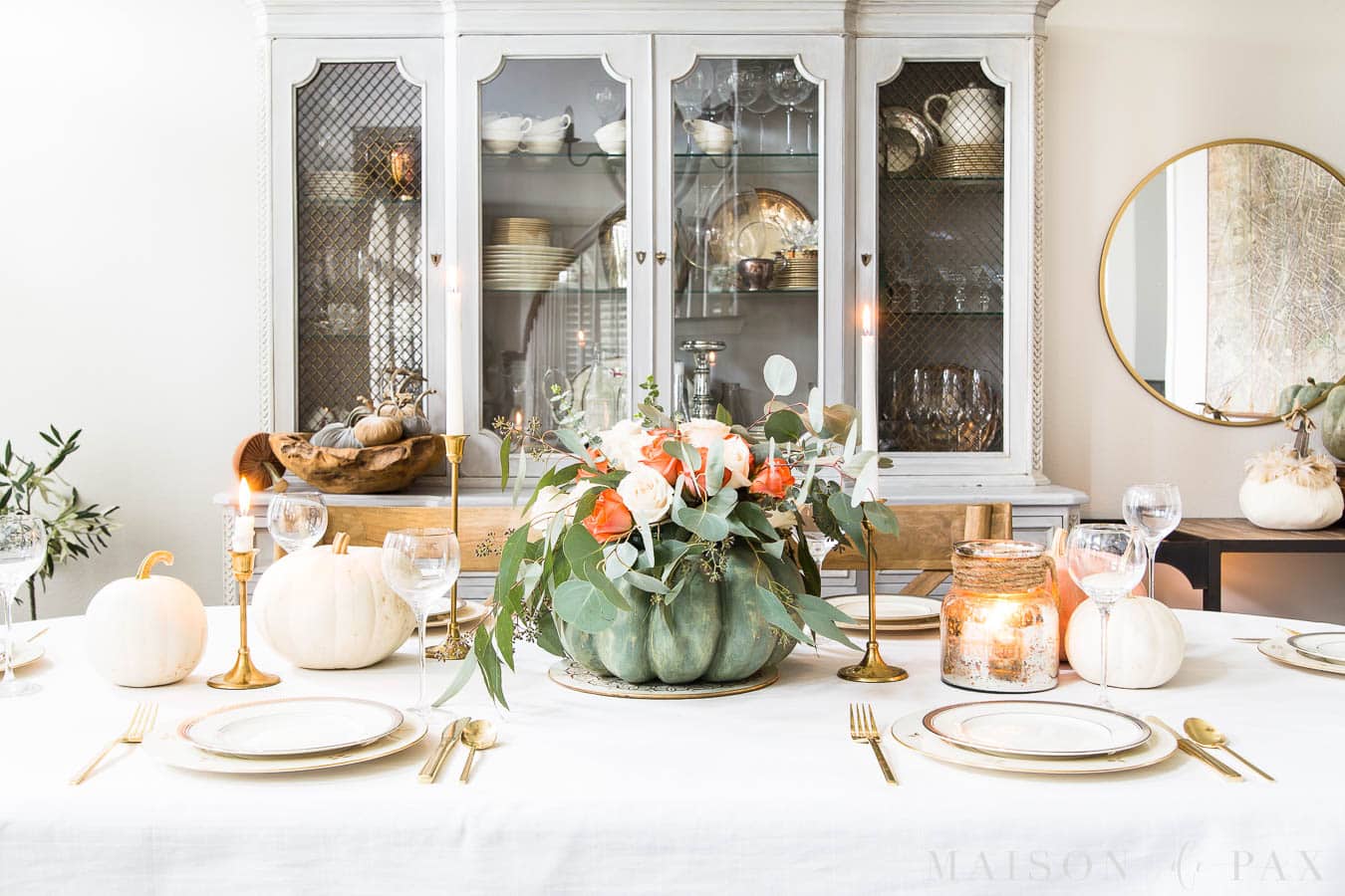 wide image of a Thanksgiving table with pumpkin floral centerpiece