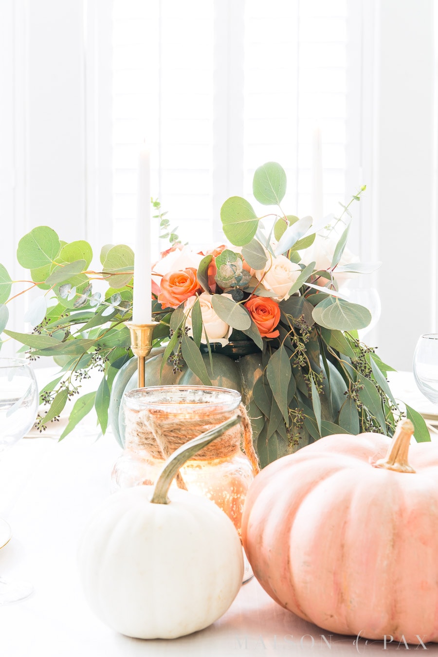 candles and pumpkins and roses on a Thanksgiving table