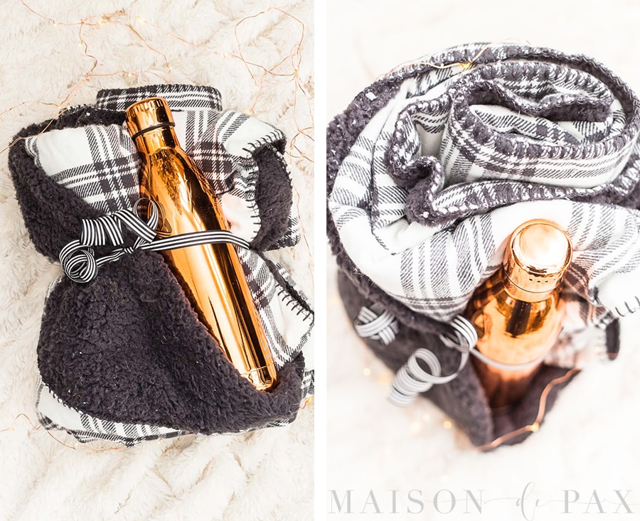 copper water bottle wrapped in a black and white plaid fleece blanket and tied with a ribbon