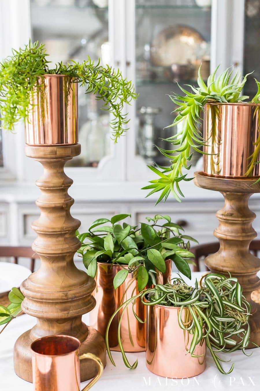 copper canisters placed atop wooden candlesticks make a simple centerpiece | Maison de Pax