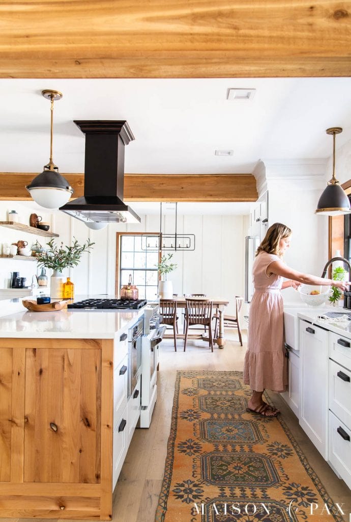 woman at sink in modern farmhouse kitchen with island | Maison de Pax