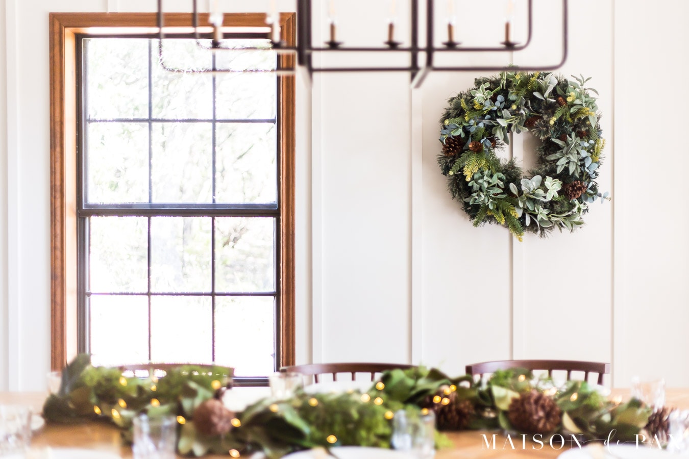 large green wreath on white walls in farmhouse dining room | Maison de Pax