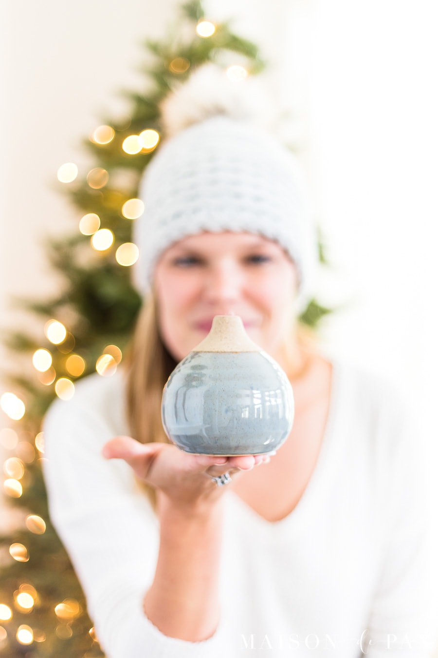 woman holding glazed bud vase in front of Christmas tree | Maison de Pax