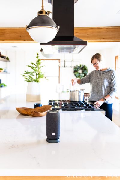 woman cooking in background with little bluetooth speaker in foreground | Maison de Pax