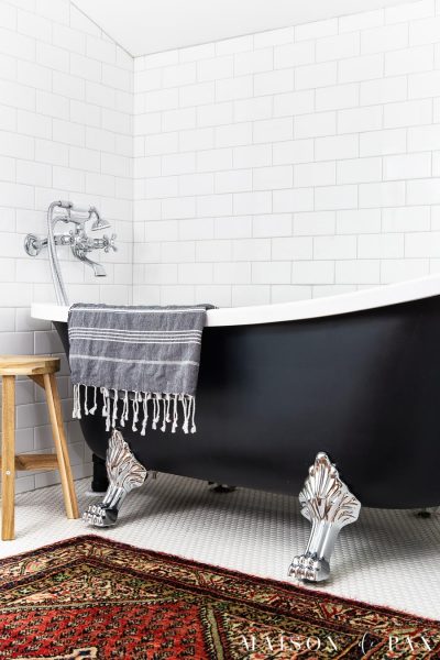 black clawfoot tub with chrome feet in white tile bathroom | Maison de Pax