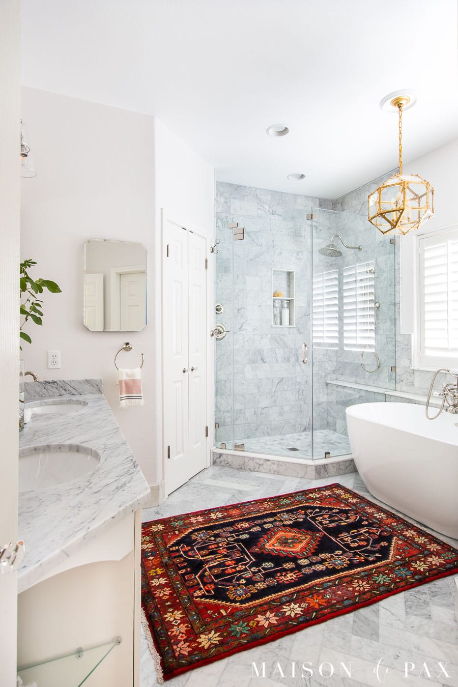 white bathroom with herringbone marble floors and gold lighting | Maison de Pax