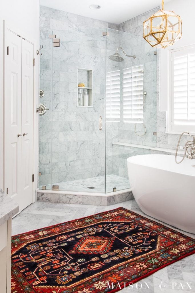 colorful vintage rug of Persian origin in marble master bathroom | Maison de Pax