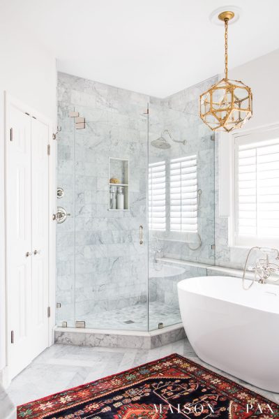 white bathroom with marble tile and freestanding tub | Maison de Pax