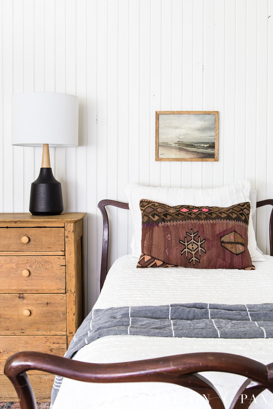 twin bed with white bedding, vintage rug pillow, and vintage art above bed | Maison de Pax