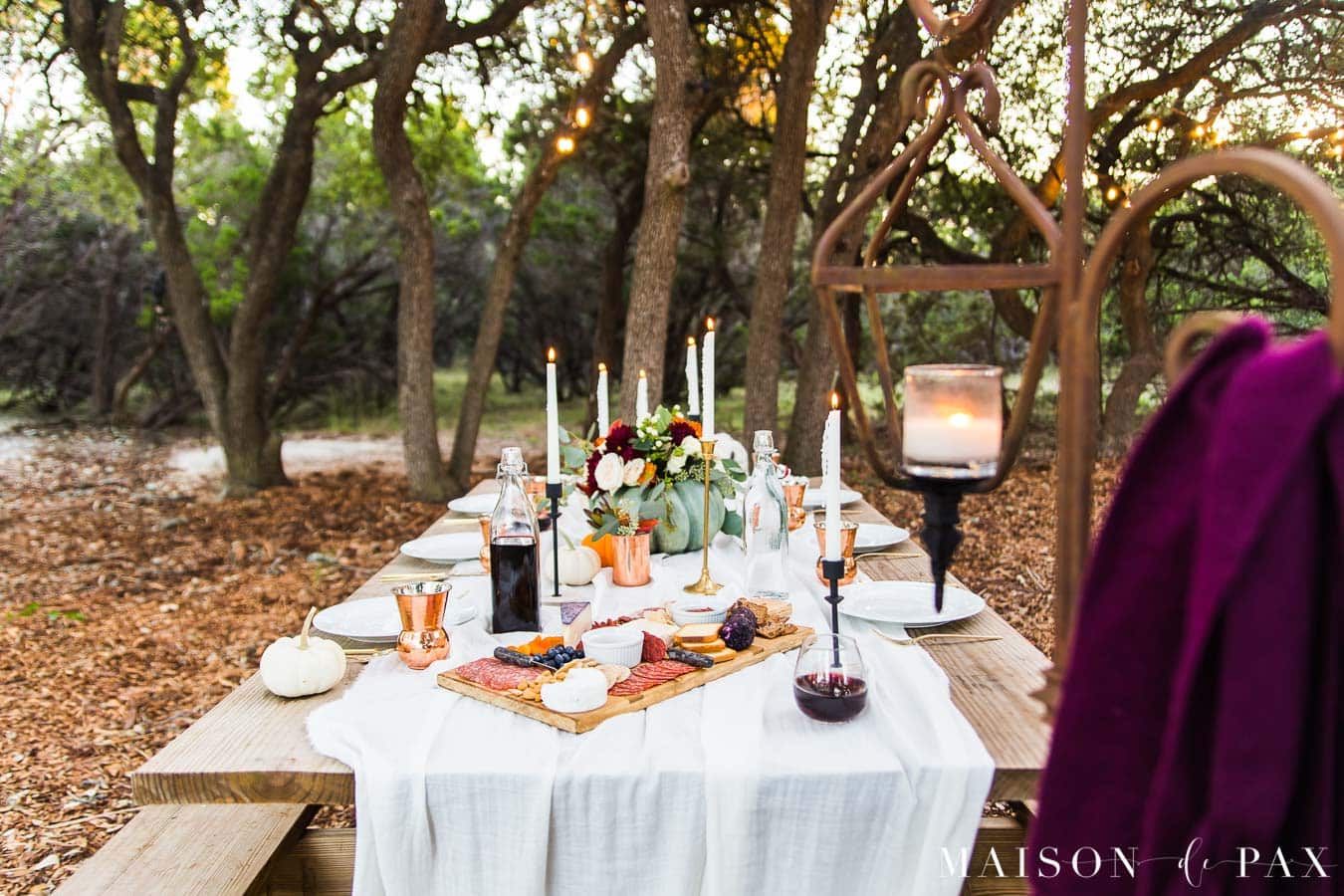 outdoor friendsgiving tablescape in woods on picnic table | Maison de Pax