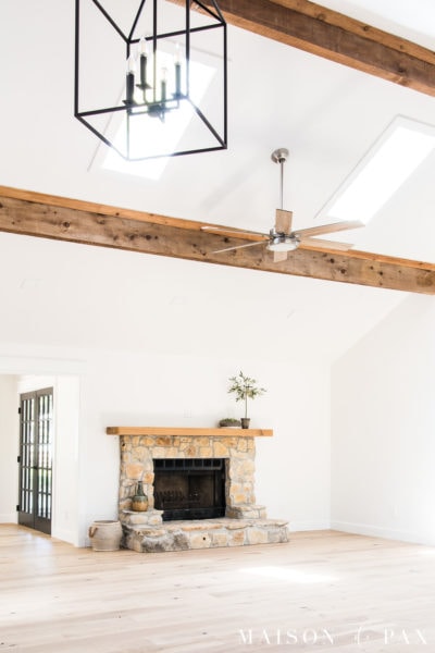 white living room with vaulted ceilings and rustic beams