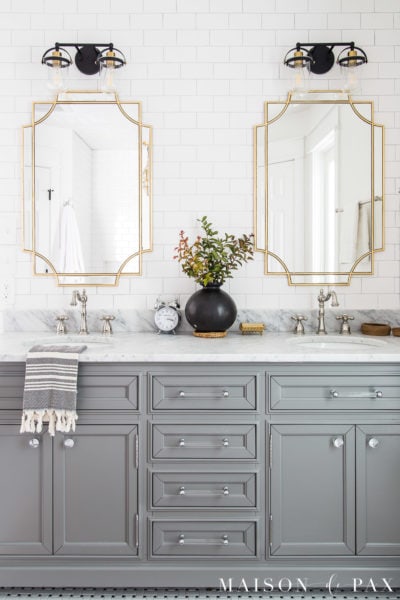 gray bathroom vanity with marble top and gold mirrors