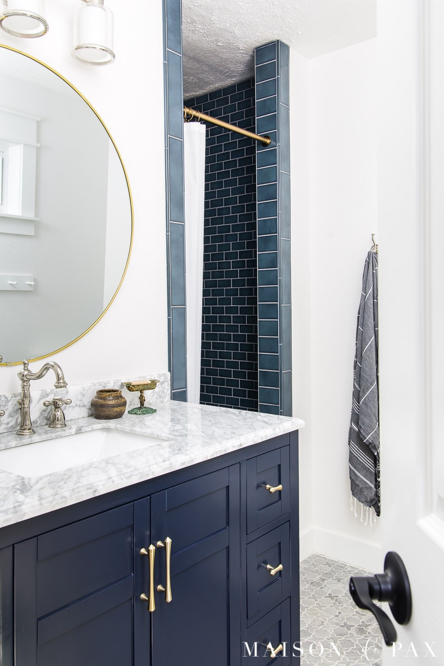 navy blue vanity and blue shower tile in blue and white bathroom