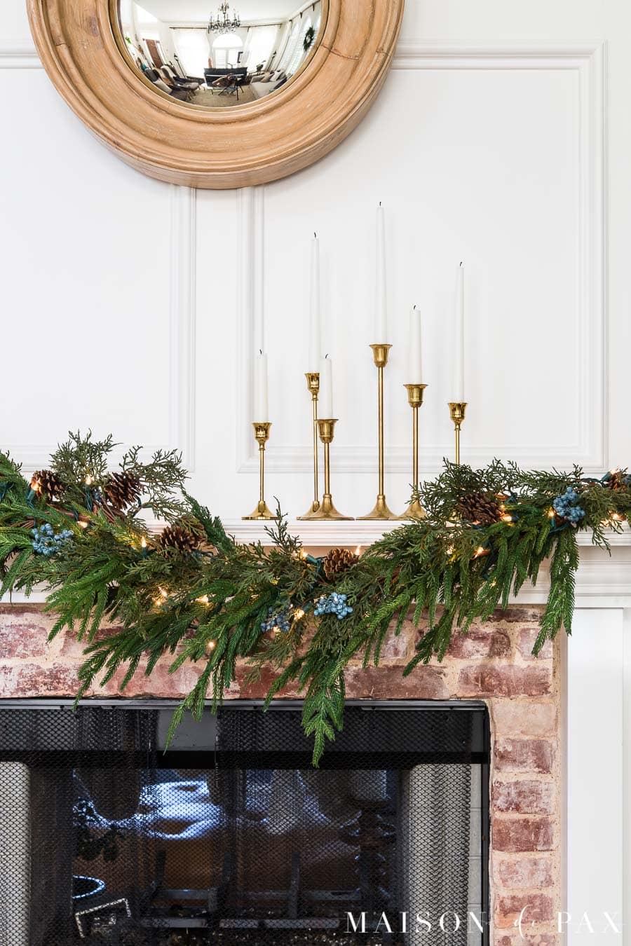 brass candlesticks and greenery for holiday mantel