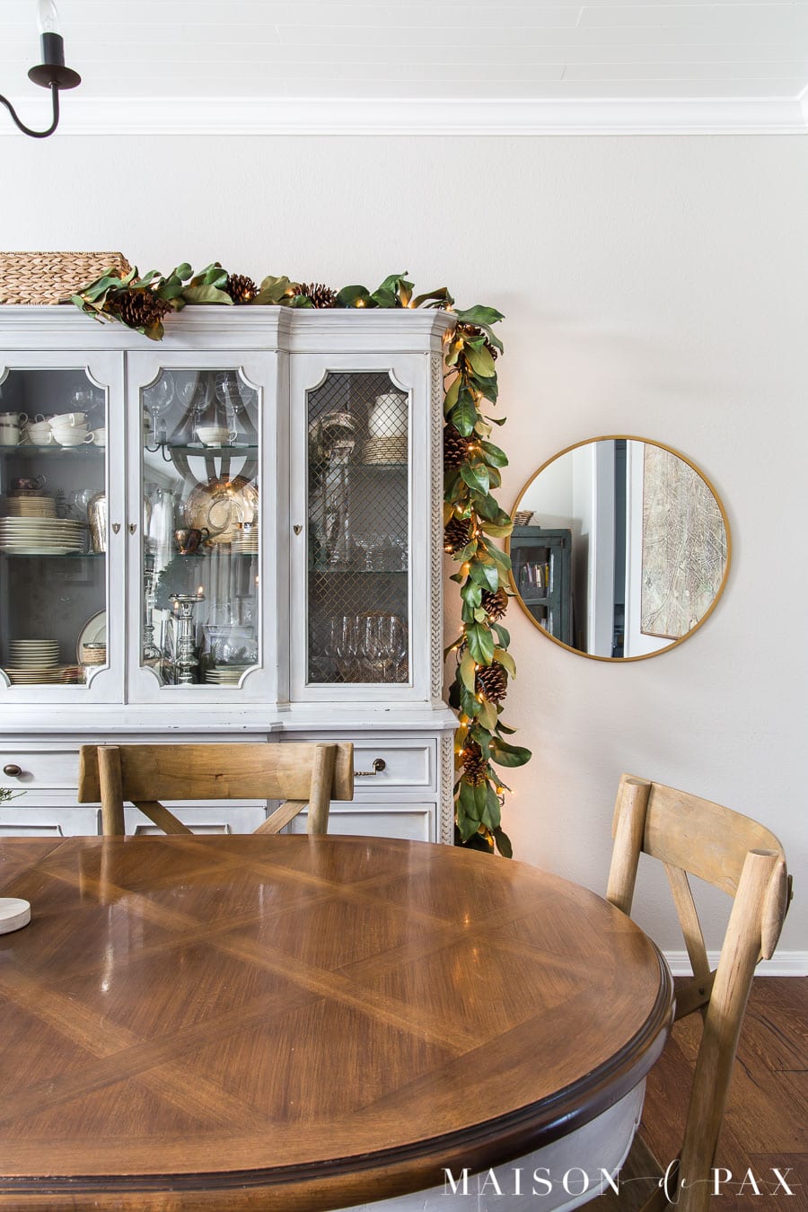 simple magnolia garland on china cabinet in dining room Christmas