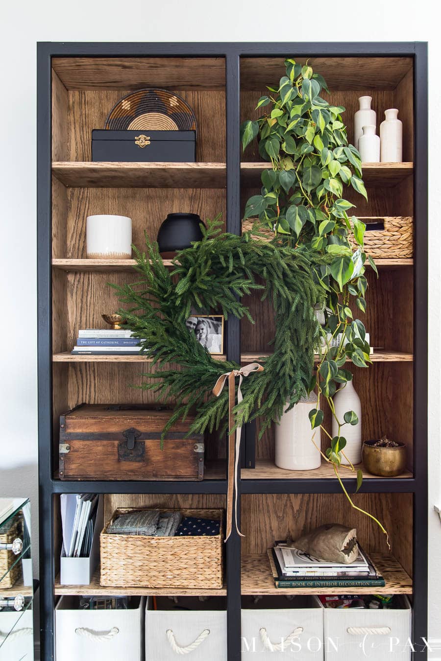 pine wreath hung on front of bookcase for holiday decorating idea