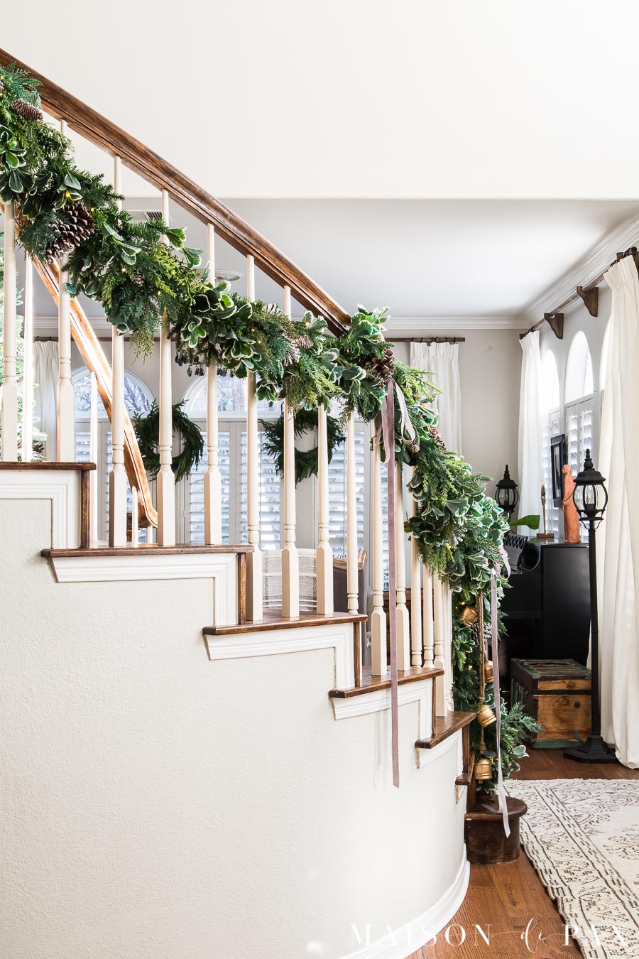 garland hung on curving staircase with velvet ribbon