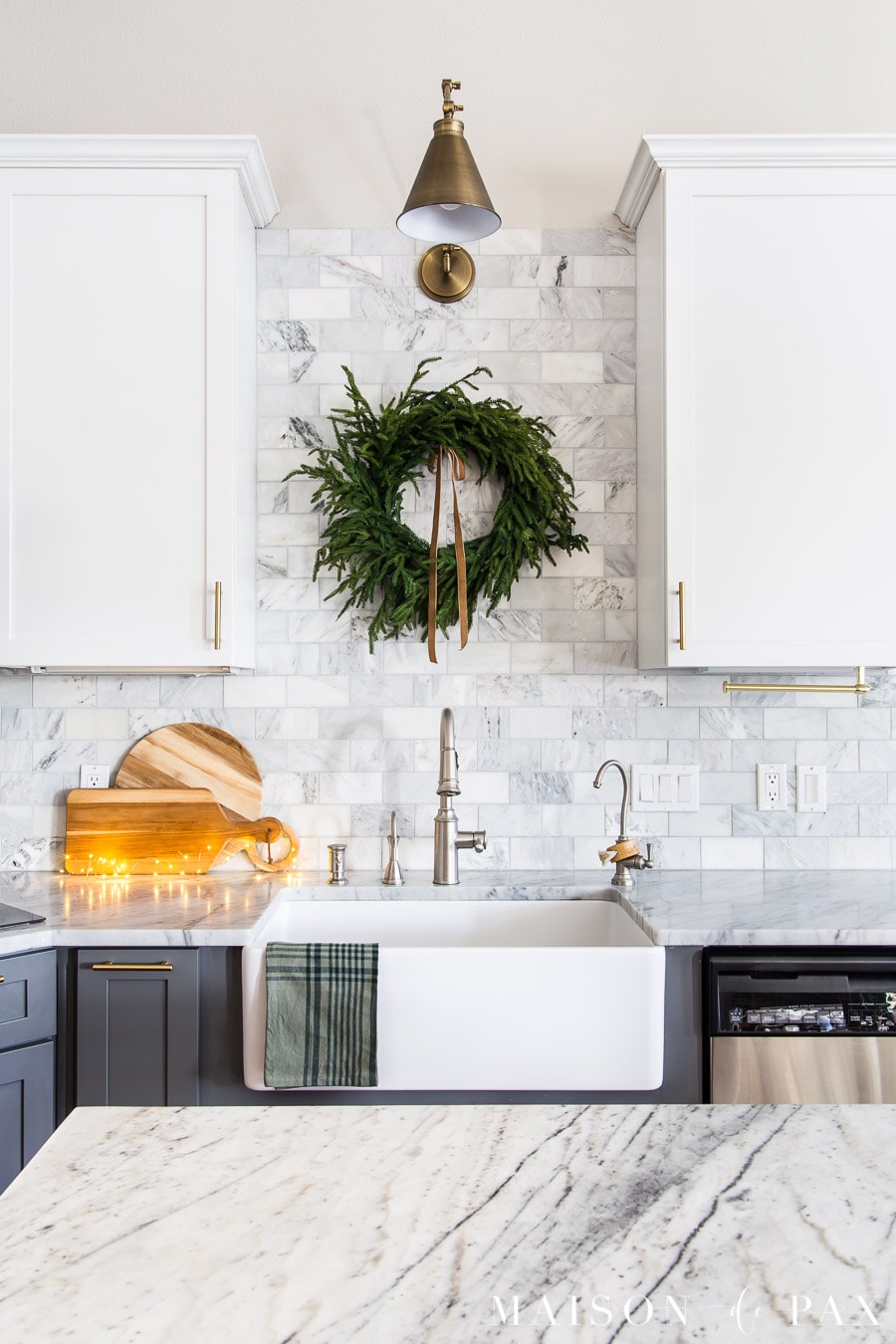 wreath above sink and copper fairy lights on kitchen counter for holiday decor
