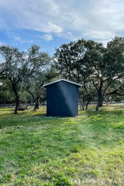 little shed with black painted walls and white trim