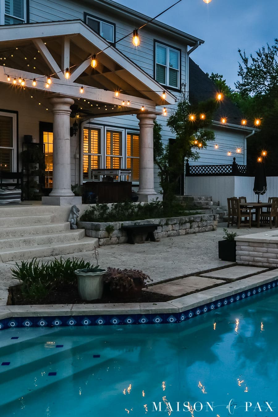 outdoor string lights hung over pool from porch
