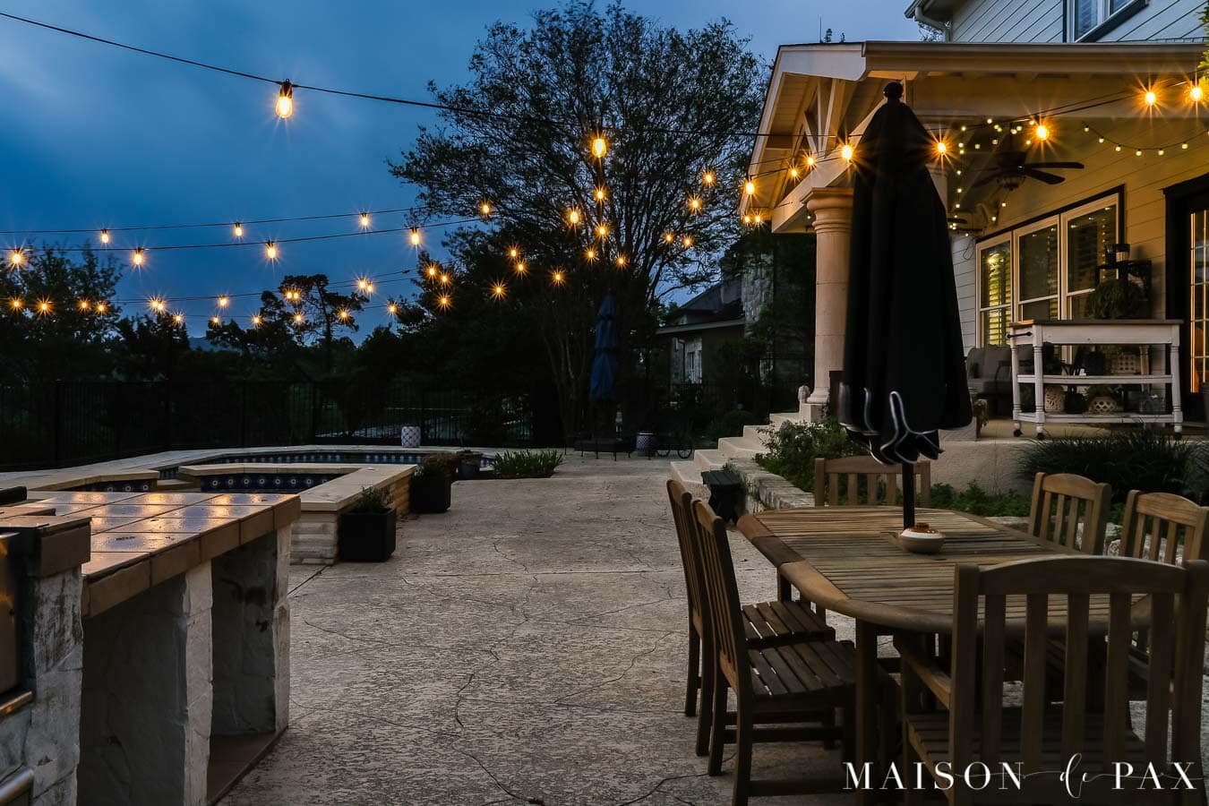 DIY string lights across concrete patio and pool