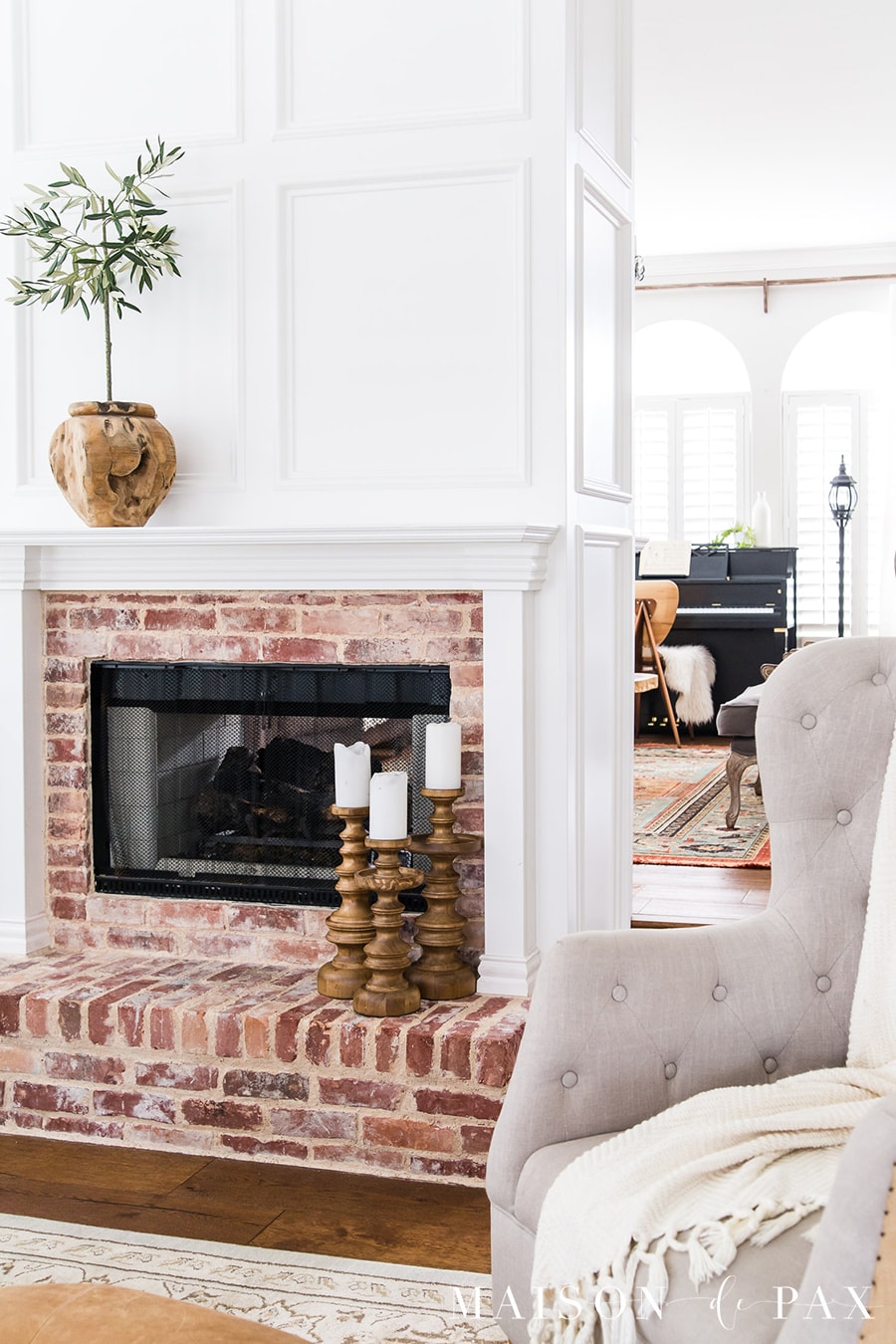 brick fireplace with white wood panel molding and trimwork