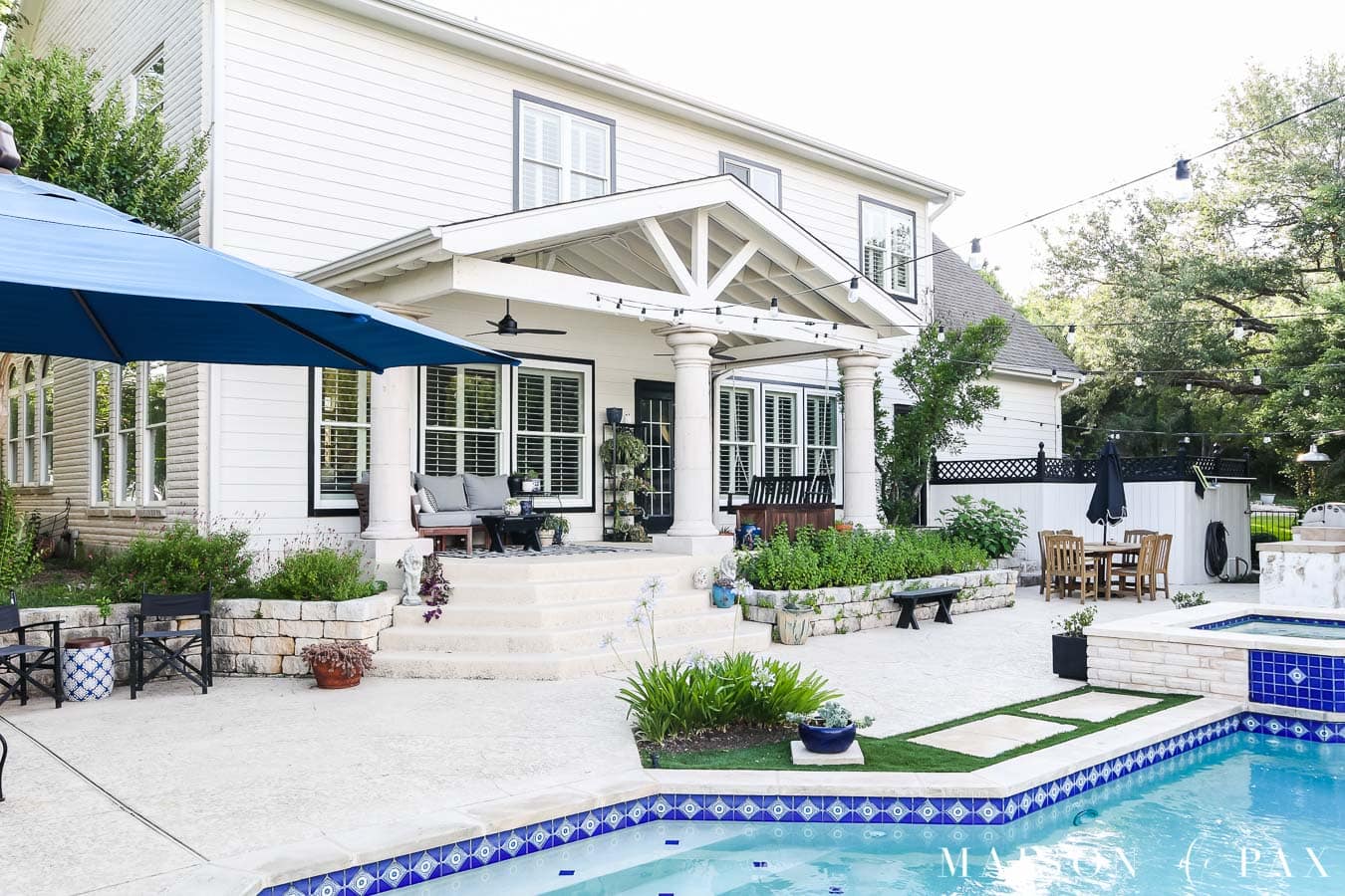 large backyard with blue umbrella over pool