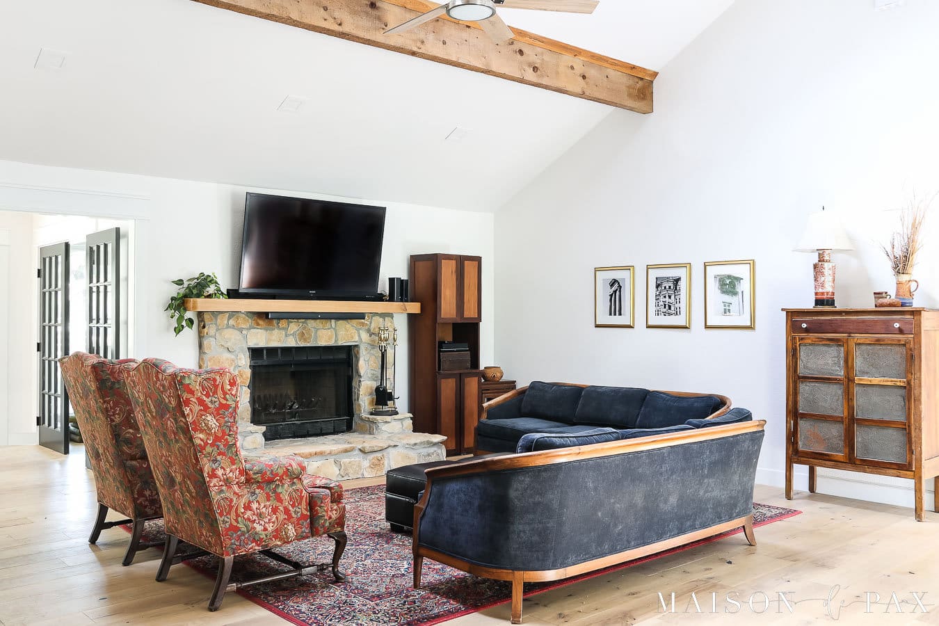 obývací pokoj s krbem, klenutým stropem a trámy