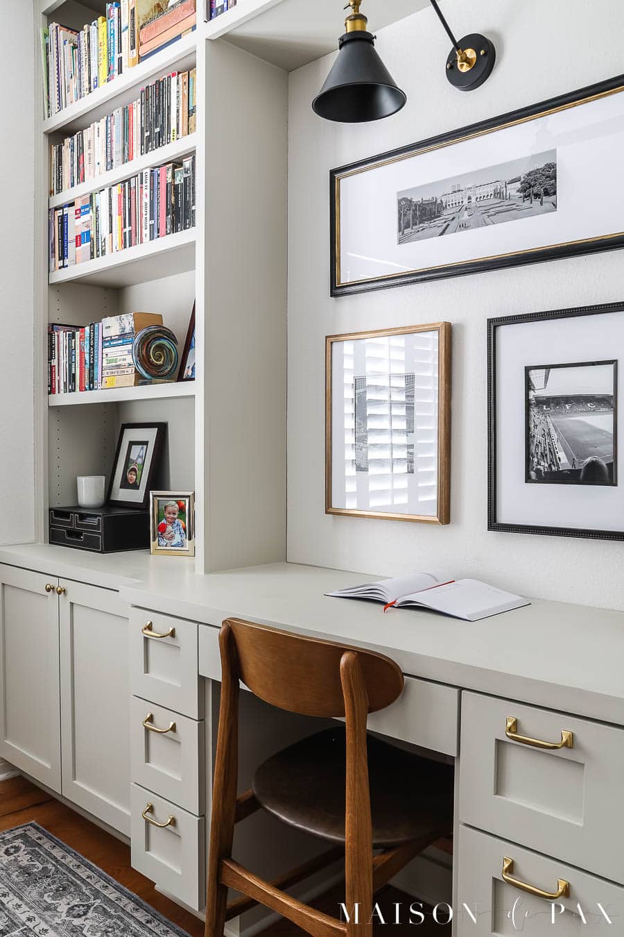 built in desk with pictures and sconce above