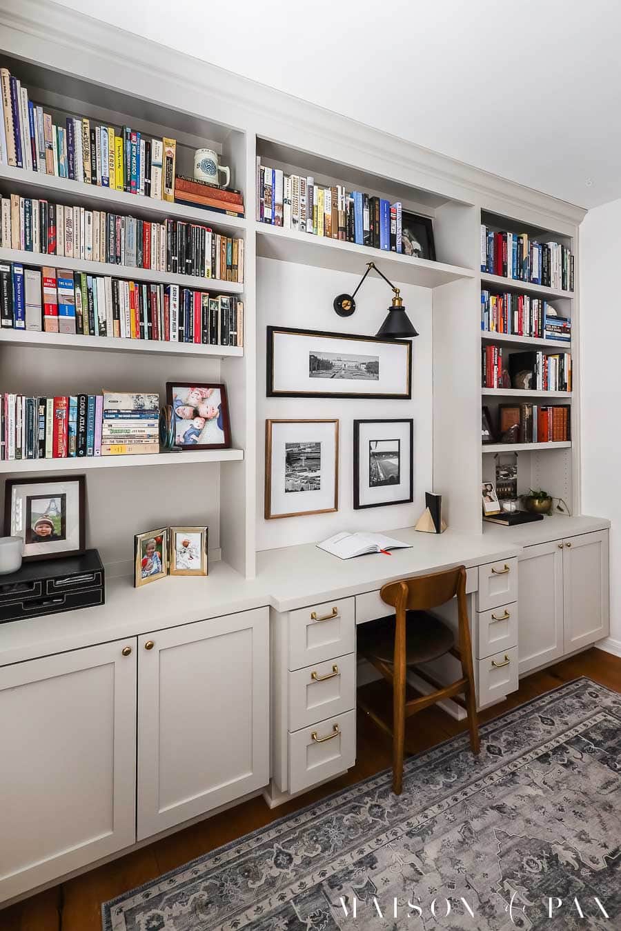 wall with built in desk and cabinets with bookcases to ceiling