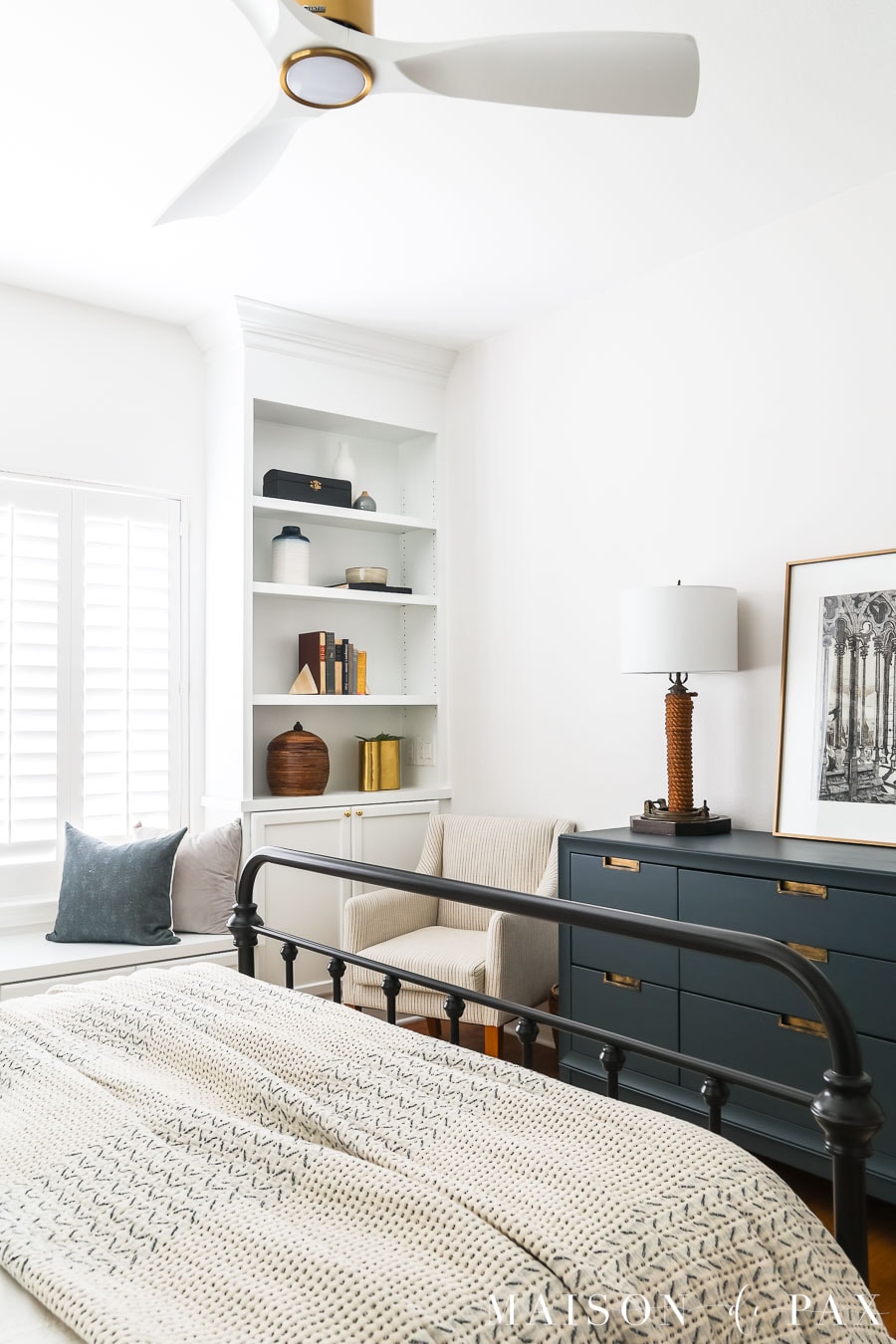 white bedroom with built in bookcases and blue dresser