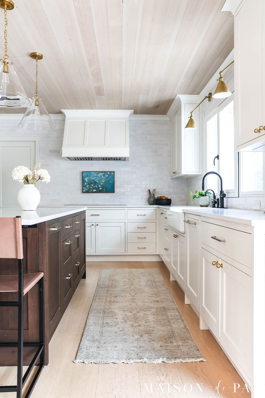 white kitchen with wood island, wood ceiling, and wood floors